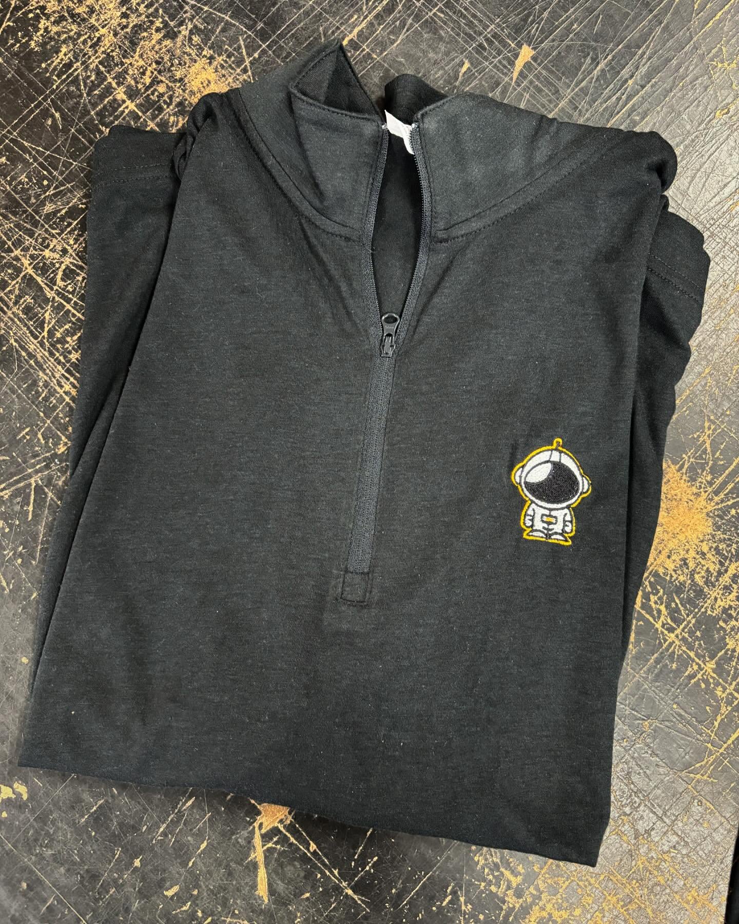 Black quarter-zip hoodie with a small astronaut embroidery on the chest.