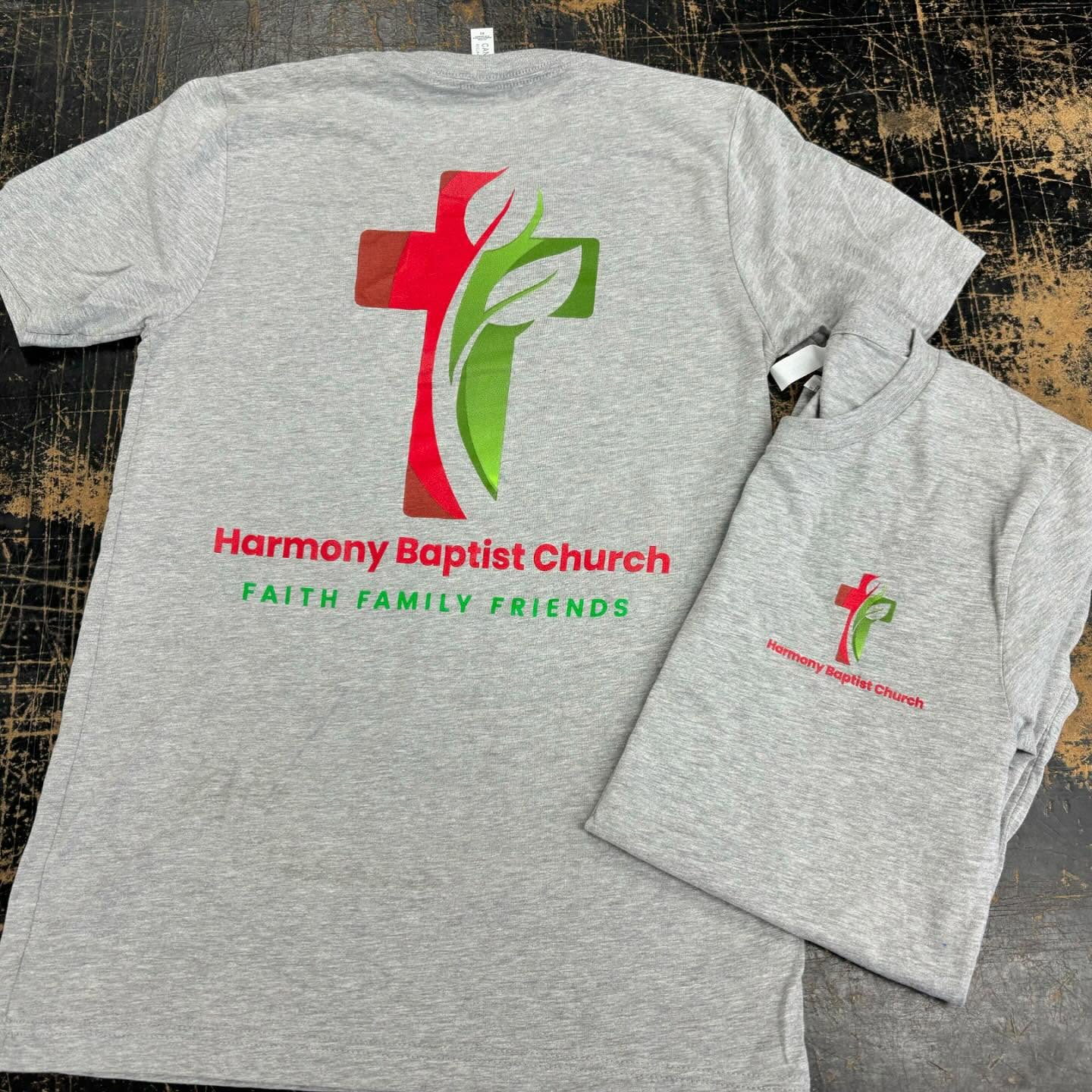 Light gray T-shirt with a red and green cross logo for Harmony Baptist Church.