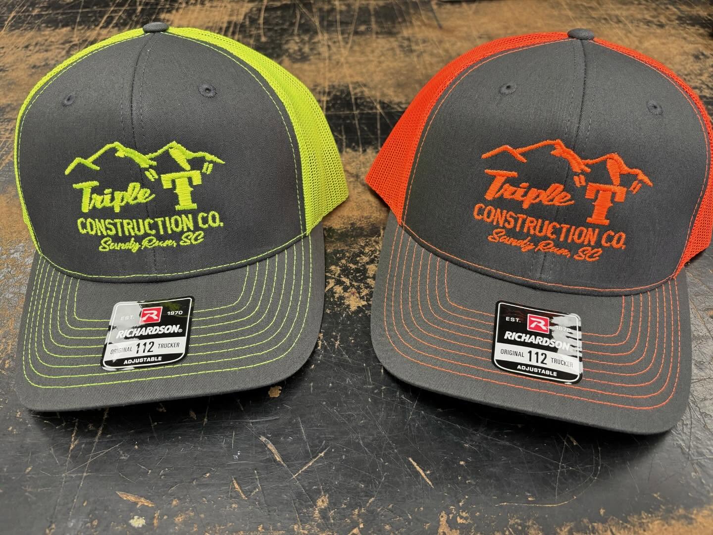 Two Richardson 112 trucker hats with Triple T Construction Co. embroidered logo in neon yellow and orange.
